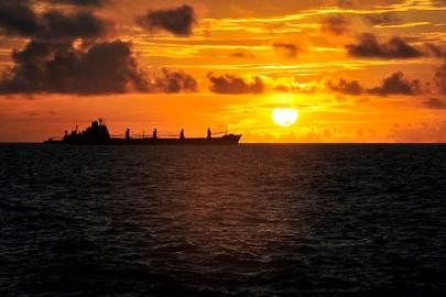 The sun rises over ships anchored off of Mogadishu, Somalia, waiting to offload their cargo.